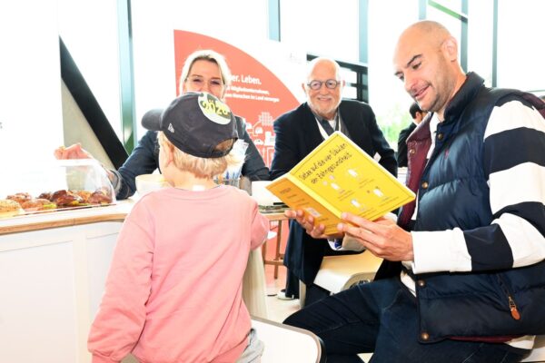 Finanzminister Dr. Danyal Bayaz (r.) entdeckte das Wimmelbuch des IZZ – und zeigte sich begeistert.