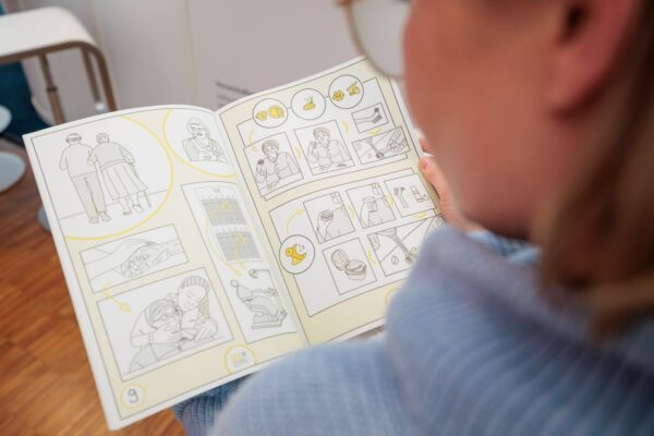 Eine Besucherin vertiefte sich in den neuen sprachfreien Flyer – ein Angebot, das viele Gespräche anregte.